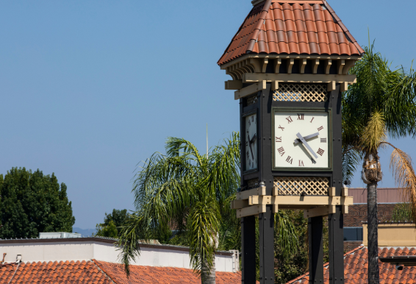 Clock tower showing two twenty five in the afternoon with blue sky in the background.